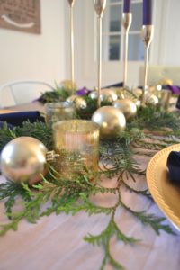 A festive tablescape using advent colors, pink and purple table decorations. Advent decorations, place settings, and centerpiece ideas